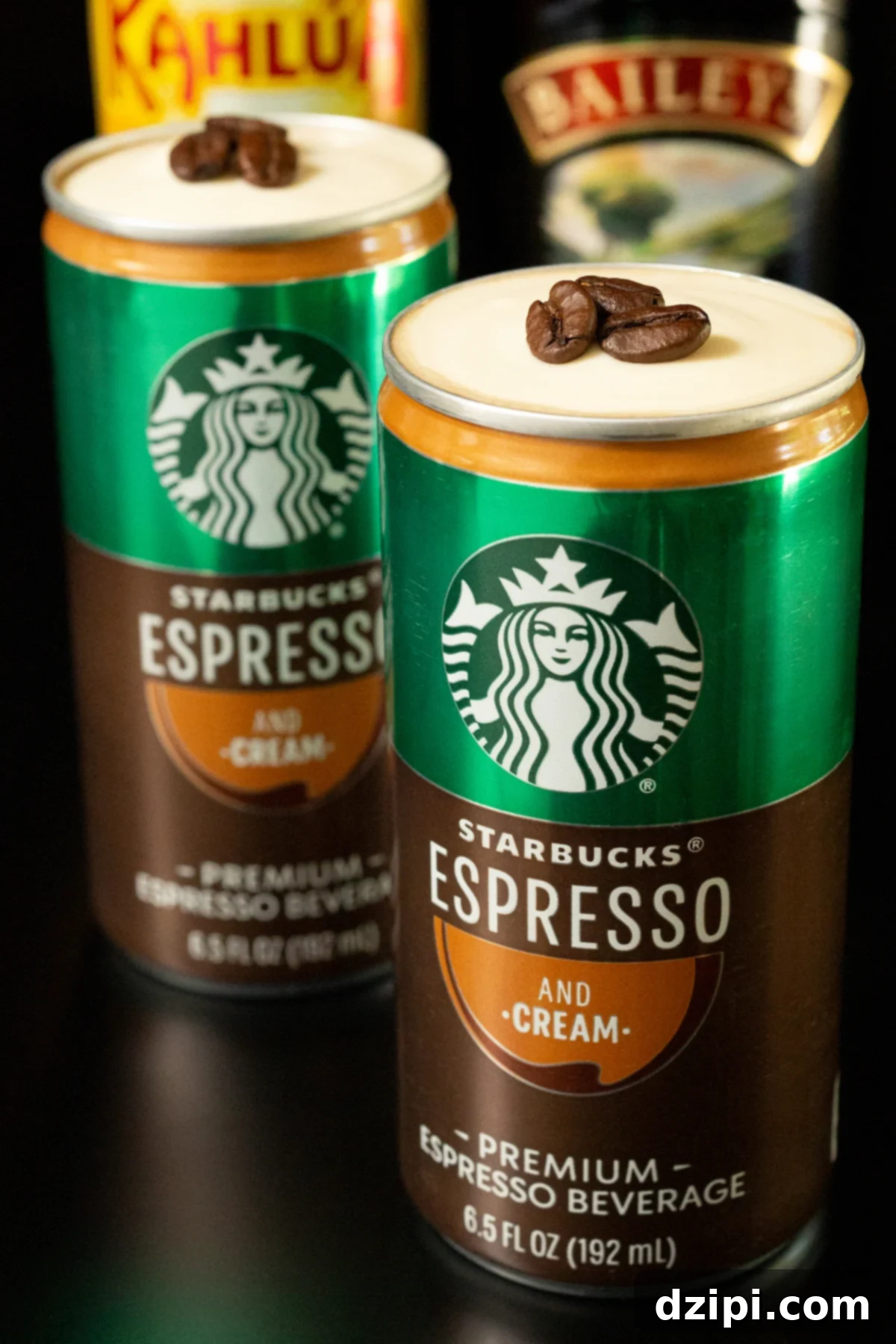 Espresso Martini Unleashed 4 In the foreground, a Starbucks Espresso and cream can stands, its top removed to reveal a luscious cold foam crowned with three espresso beans. Slightly out of focus in the background are another can and bottles of Kahlua and Bailey's, hinting at the delightful ingredients.