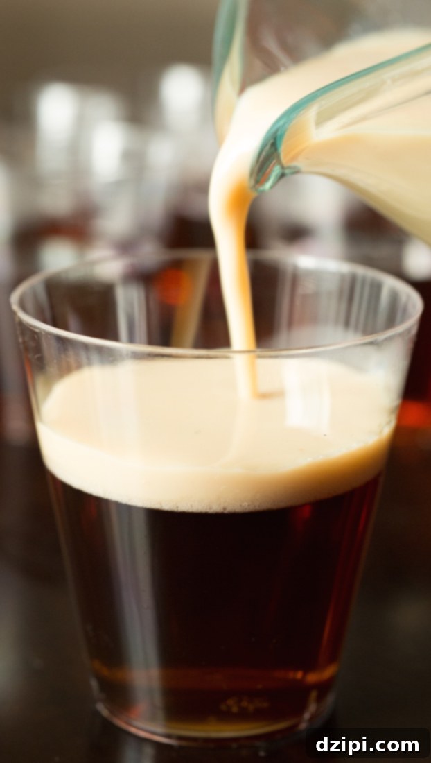 Step-by-step guide on how to make layered Irish Slammer Jello Shots using Guinness, Irish Whiskey, and creamy Bailey's for a festive St. Patrick's Day treat.