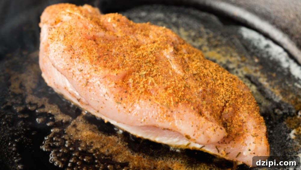 Blackened chicken being seared in the cast iron skillet.