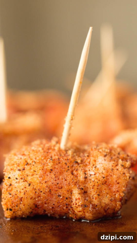 Close up of bacon wrapped chicken bites on toothpicks.