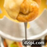 Beer Cheese Fondue made with garlic, lager beer, sharp cheddar, and gruyere. Served with homemade mini soft pretzels.