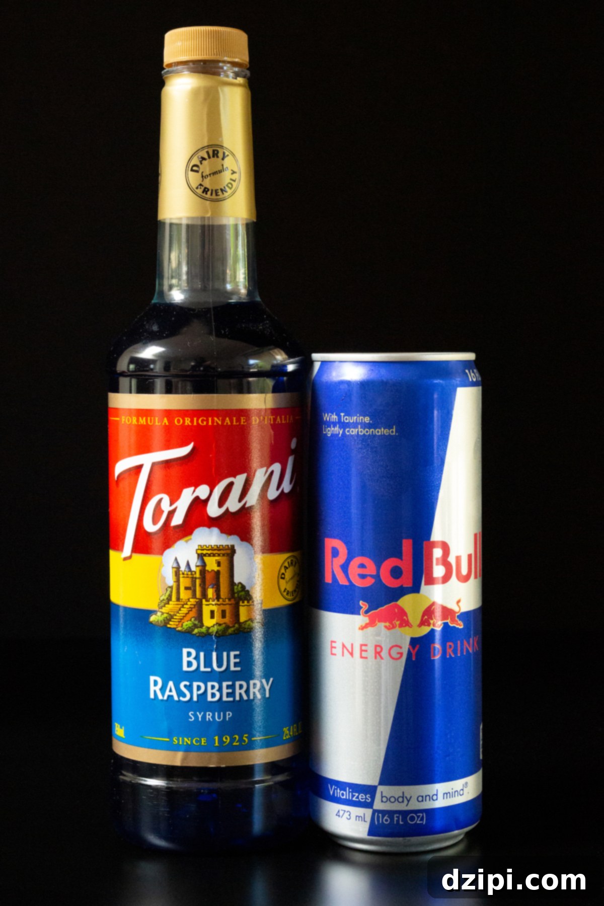 Red Bull Freeze 4 A bottle of Torani blue raspberry syrup and a can of Red Bull on a black background.