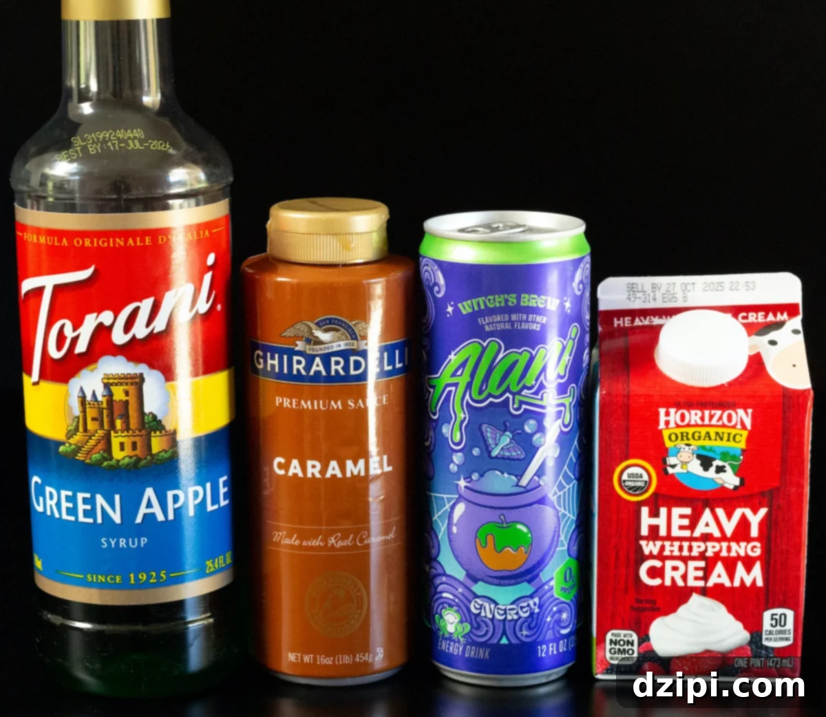 A bottle of Torani green apple syrup, Ghirardelli caramel sauce, a can of Alani Witch's Brew energy drink, and a pint of heavy cream.