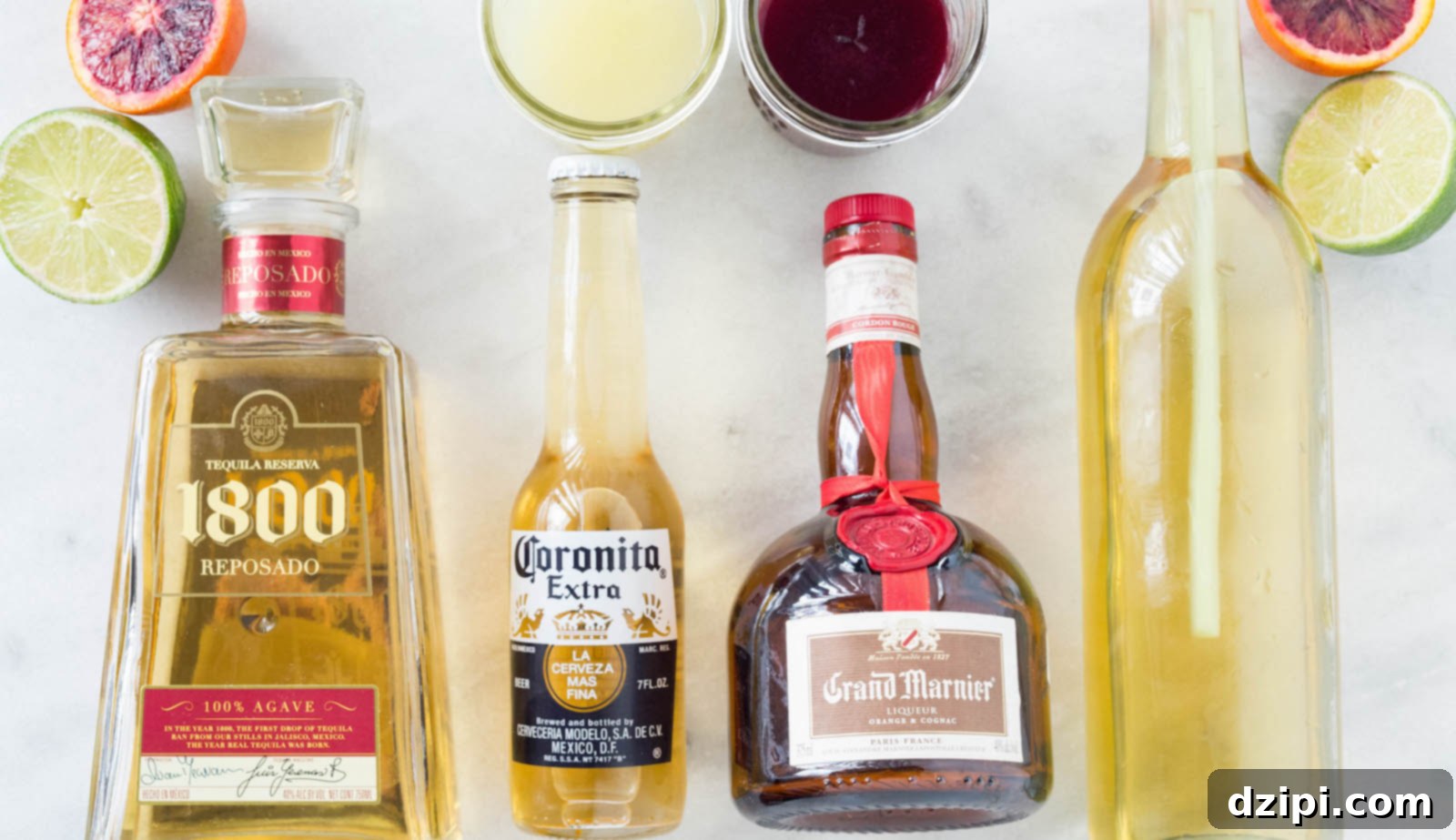 The Perfect Blood Orange Lemongrass CoronaRita 3 Ingredients laid out for a Blood Orange Lemongrass CoronaRita: fresh blood orange slices, vibrant blood orange juice, zesty lime juice, a small bottle of Coronita beer, a shot of tequila, a bottle of Grand Marnier, and a homemade lemongrass simple syrup.