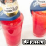 The Perfect Blood Orange Lemongrass CoronaRita 7 A high-angle shot of a single Blood Orange CoronaRita in a large glass, garnished with a fresh blood orange slice. The inverted Coronita bottle stands prominently in the vibrant orange cocktail.