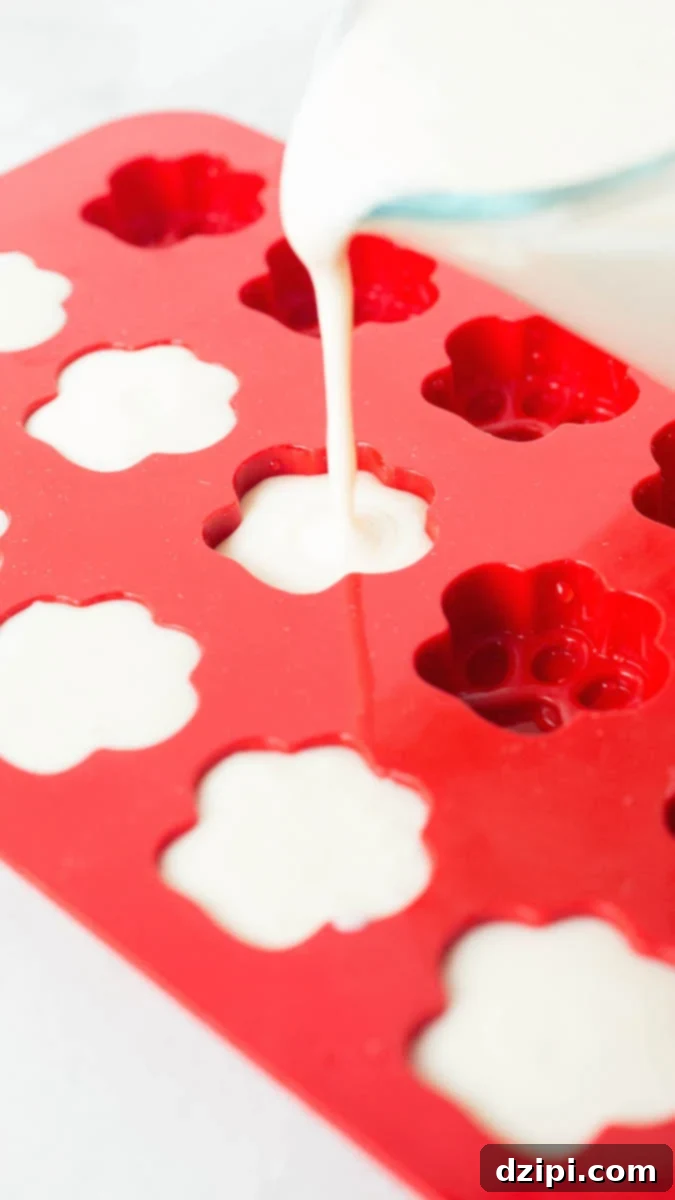 Filling up a paw shaped mold to make yogurt peanut butter banana dog treats. The process is quick and mess-free.