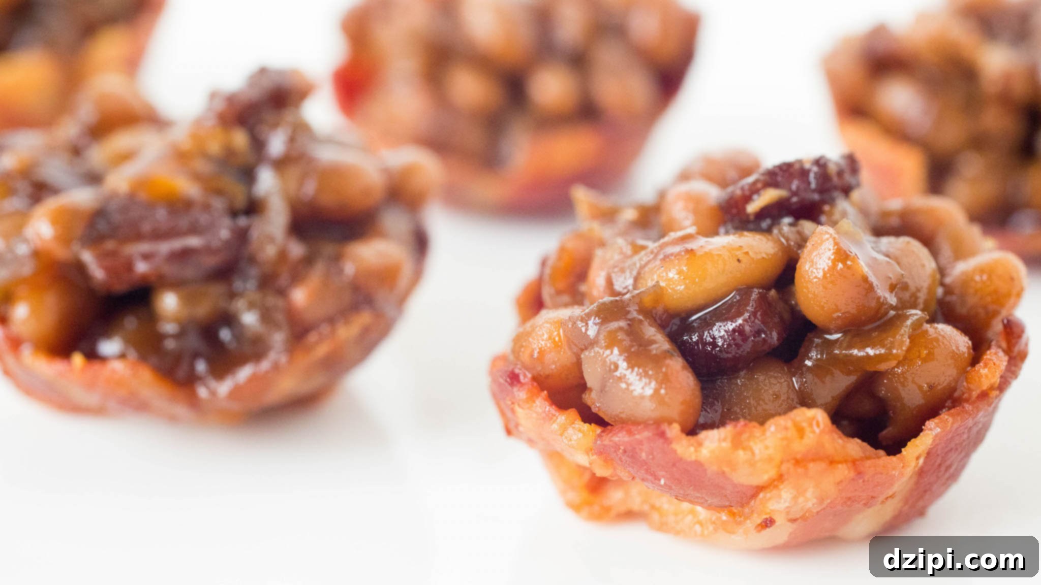 Crispy mini bacon bowls filled with homemade baked beans, ready to serve as a perfect BBQ appetizer.