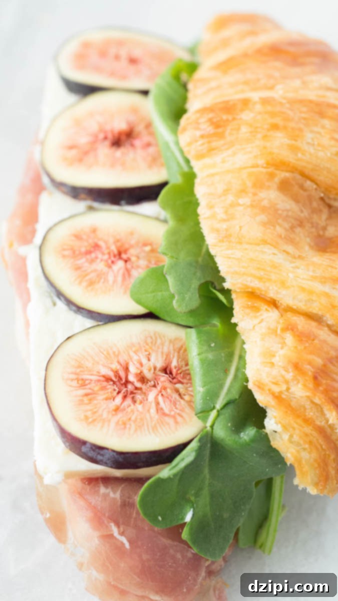 Close up of a croissant sandwich recipe made with figs, blue cheese, prosciutto, and arugula.