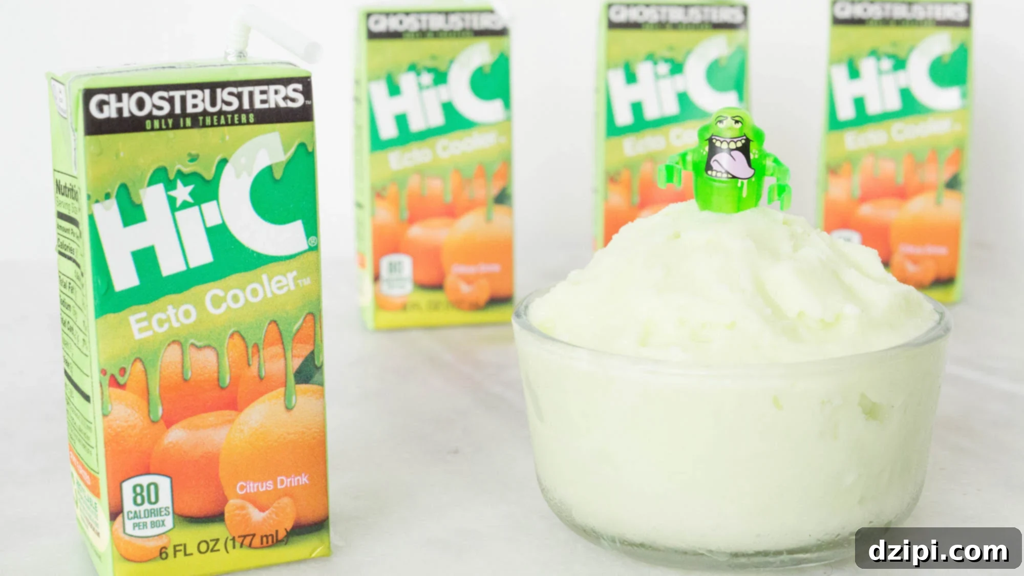 A refreshing glass bowl of bright green Ecto Cooler sherbet, topped with a Lego Slimer ghost. Hi-C Ecto Cooler cartons are arranged around the bowl, evoking 90s nostalgia.