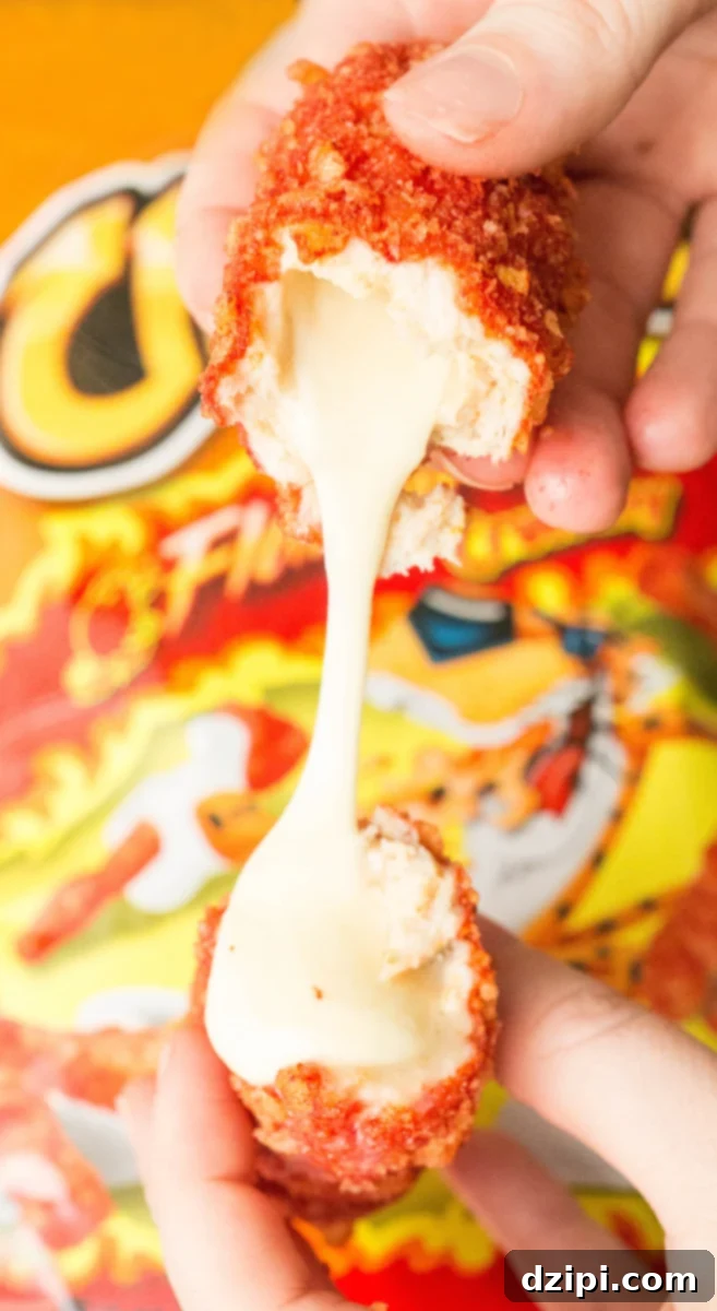 A close-up shot of a Flamin' Hot Cheetos covered mozzarella stick being pulled apart, showcasing the irresistible stretch of melted cheese, highlighting the spicy, crunchy exterior.