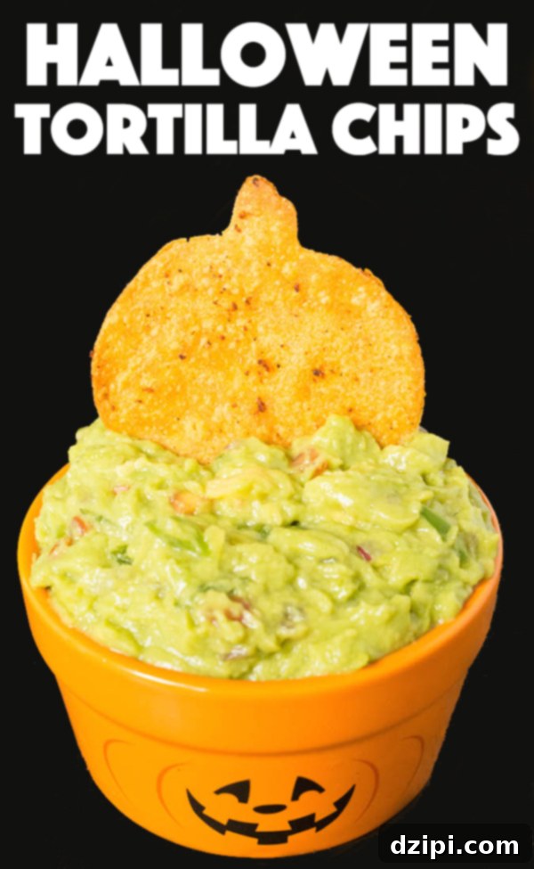 Spooktacular Tortilla Chip Trio 2 A vibrant pumpkin-shaped tortilla chip, richly seasoned, is shown perfectly dipped into a creamy, green guacamole, highlighting a festive and delicious Halloween appetizer.