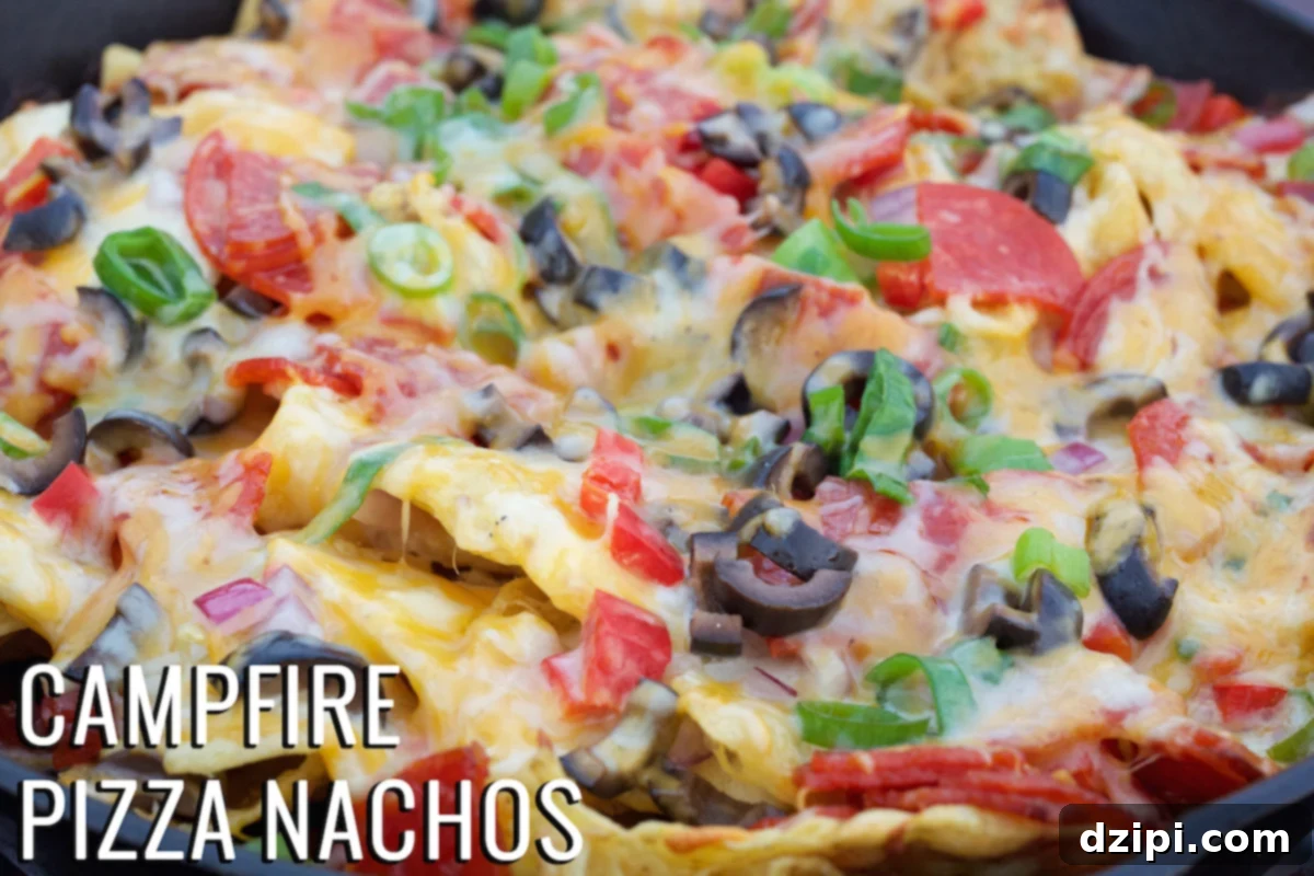 Delicious Campfire Pizza Nachos bubbling in a cast iron skillet over an open fire.