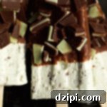 Cool Mint Chocolate Cheesecake Popsicles 5 Close up of a mint chocolate cheesecake popsicle. The top half is coated in chocolate and chopped andes mints.