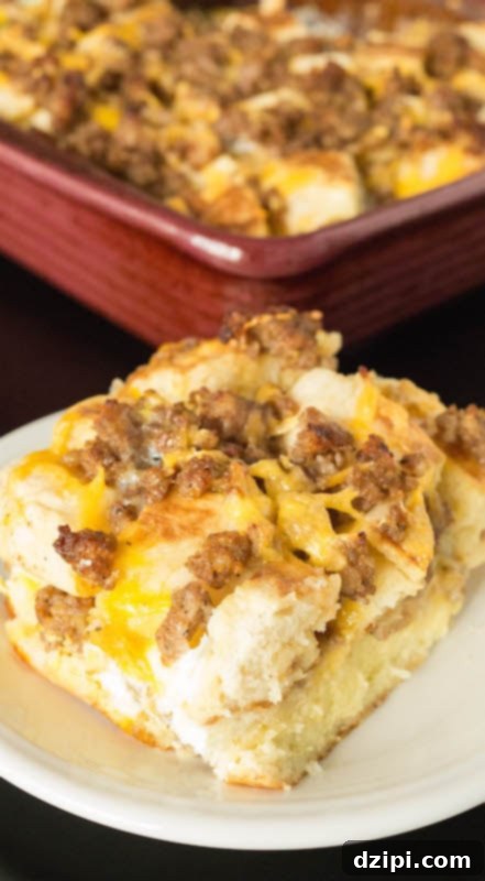 A slice of Sausage Egg McMuffin Casserole in front of the dish with the rest of the breakfast casserole.