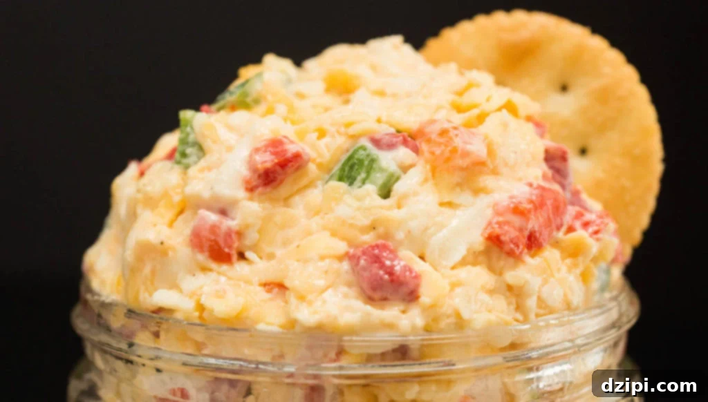 Creamy pimento cheese with diced jalapeños, ready to be served, on a dark background.