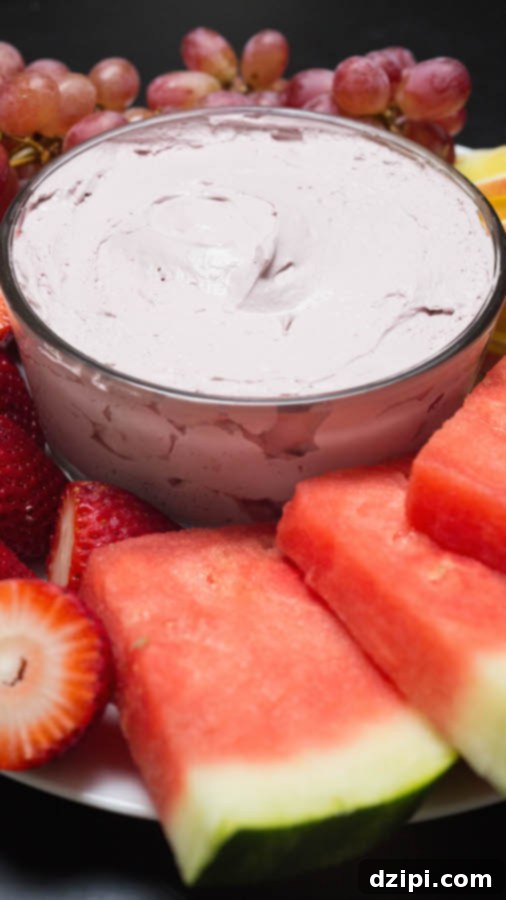 A beautifully arranged bowl of Red Wine Fruit Dip, surrounded by an abundant selection of various colorful fruits.