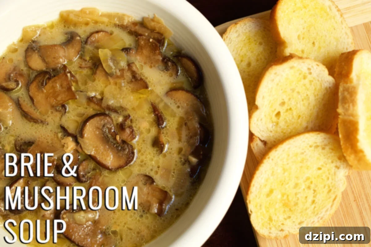 A bowl of creamy mushroom and brie soup, garnished, with a sliced baguette on a cutting board beside it. Text on the image reads "Brie & Mushroom Soup".