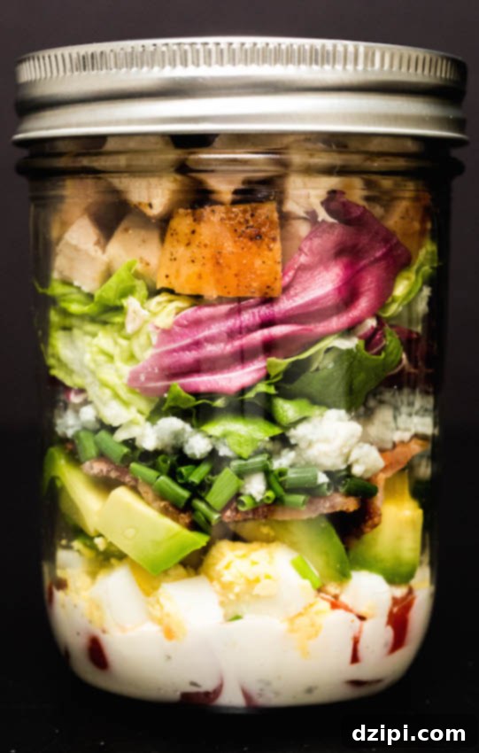 Ultimate Mason Jar Cobb Salad 4 A beautifully layered Mason Jar Cobb Salad, ready for a healthy meal.