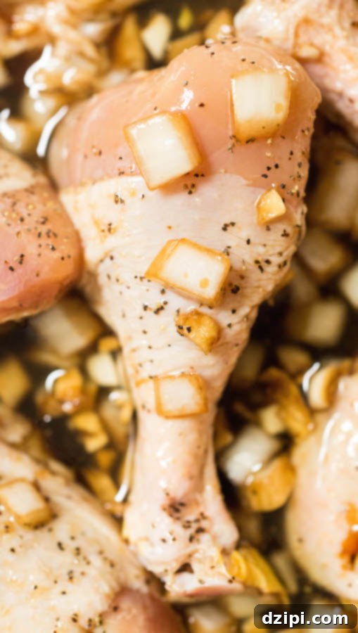 A raw chicken drumstick immersed in a golden-brown marinade, showcasing its rich texture and aromatics.