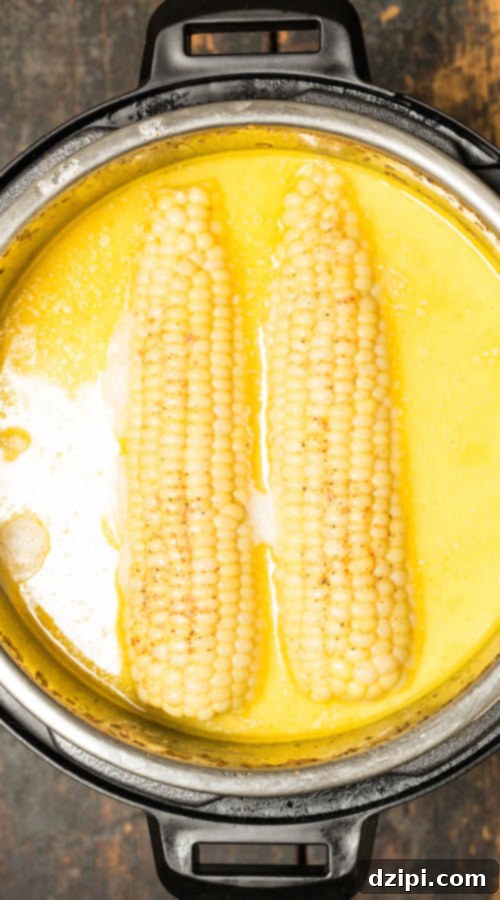 Instant Pot Milk and Honey Corn Delight 3 Two perfectly cooked ears of corn submerged in a rich, creamy milk and honey liquid inside the Instant Pot, highlighting the infusion process.