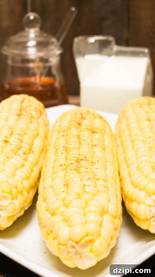 Instant Pot Milk and Honey Corn Delight 4 Three golden ears of Instant Pot Milk and Honey Corn on the Cob, freshly prepared, with rustic glass jars of honey and milk in the background, ready to be served.
