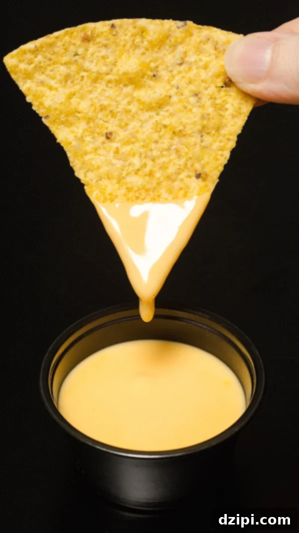 Copycat Taco Bell Cheese dripping from a tortilla chip.