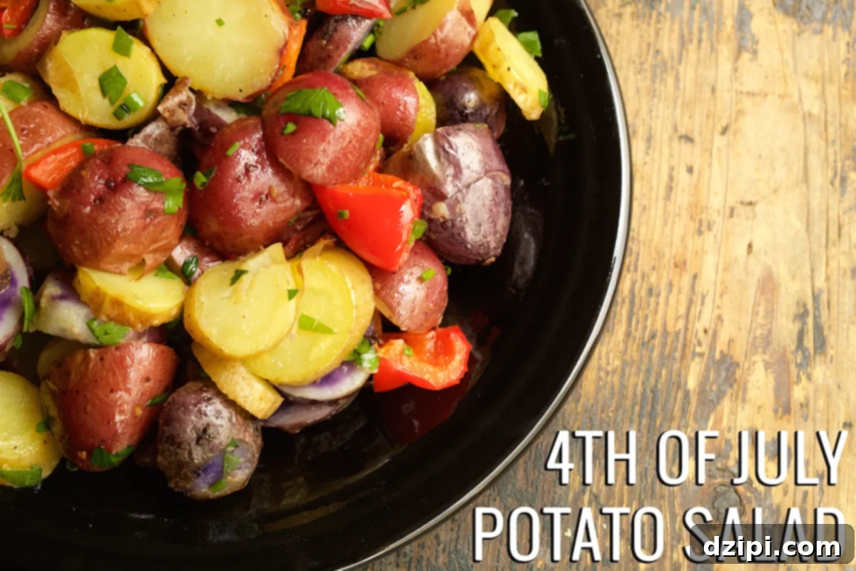 A plate of vibrant multi-colored potato salad, perfect for a 4th of July celebration. Text in the left corner reads "4th Of July Potato Salad".