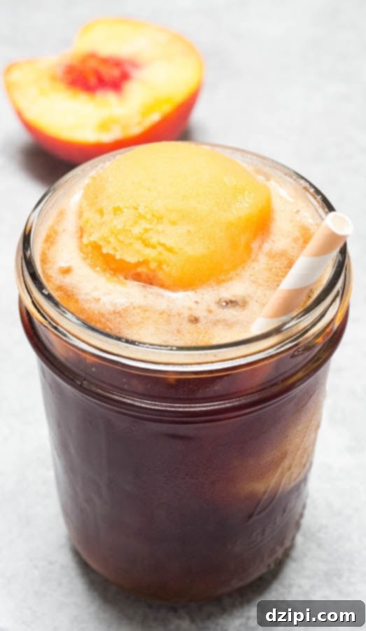 Peachy Tea Cloud Float 3 A charming mason jar filled with classic Southern Sweet Tea, topped with a luscious scoop of homemade Peach Sorbet, ready to be enjoyed.
