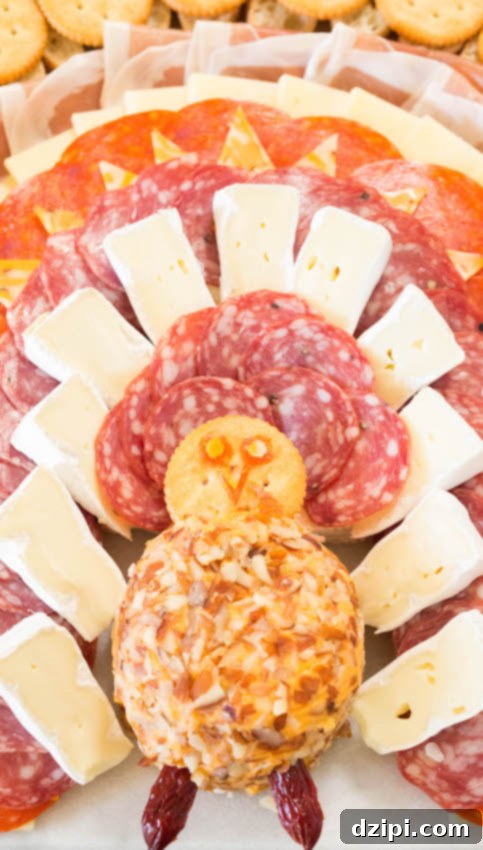 Close-up of the turkey's head and neck on a Thanksgiving charcuterie board, made from a cheese ball, cracker, and sliced meats.