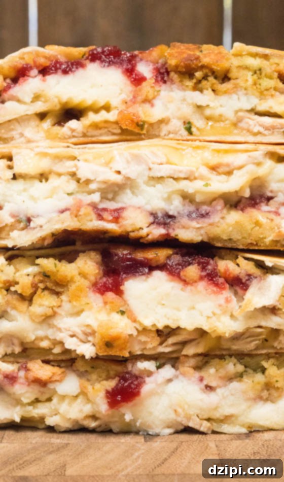 Next-Level Thanksgiving Leftover Crunchwrap 5 A close-up view of the cross-section of a Thanksgiving Leftovers Crunchwrap Supreme, clearly showing the distinct, savory layers of filling and the perfectly toasted, crispy tortilla shell.