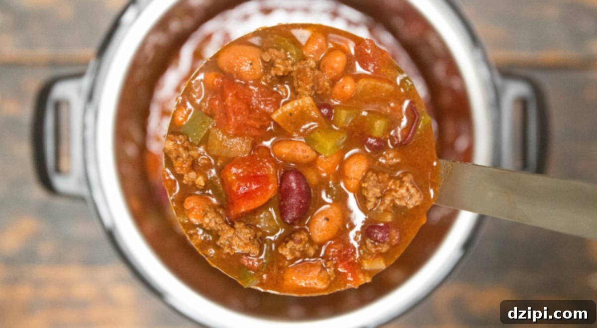 Instant Pot Copycat Wendys Chili 2 A ladle with hearty, rich Instant Pot Copycat Wendy's Chili over an Instant Pot, showcasing the texture of the beans and meat.