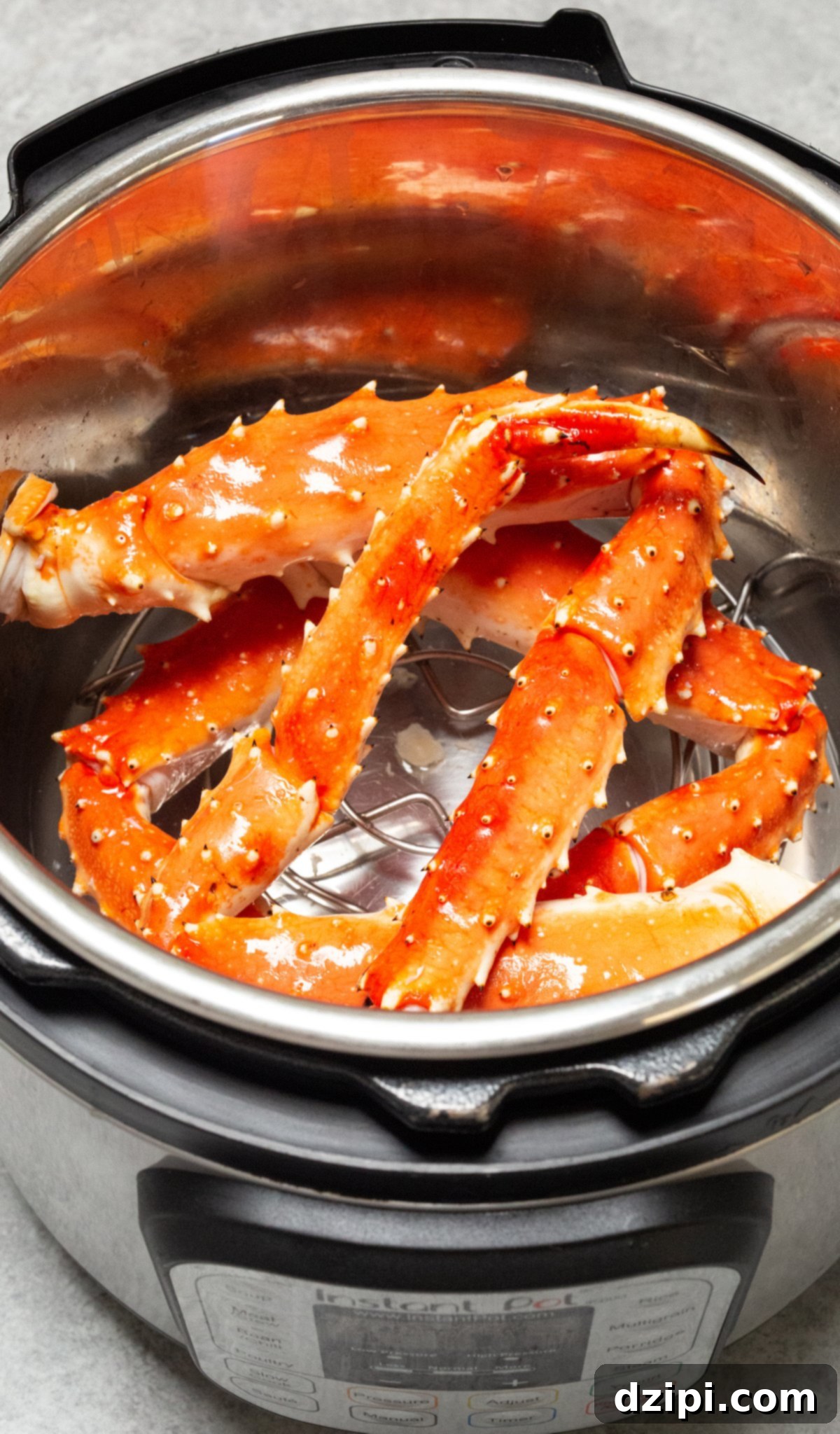 Overhead view of an Instant Pot that is full of vibrant King Crab legs, perfectly steamed and ready to eat.