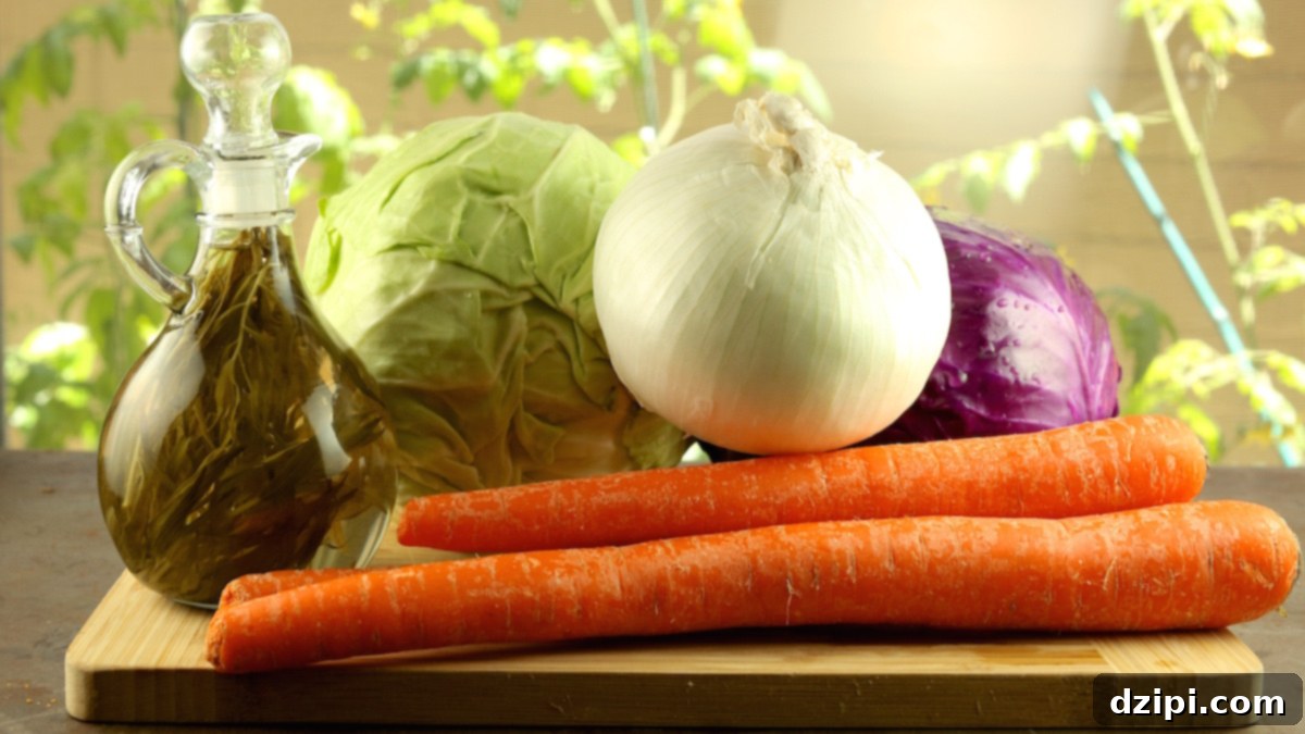 KFC Coleslaw Ingredients on a cutting board. Carrots, tarragon vinegar, onion, purple cabbage and green cabbage.