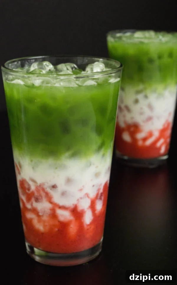 Two vibrant Iced Strawberry Matcha Lattes elegantly presented on a sleek black background.