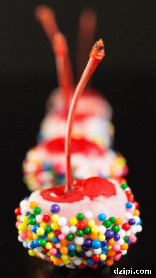 Confetti Cherry Bombs 2 Birthday Cake Cherry Bombs (maraschino cherries soaked in cake vodka then dipped in white chocolate and rainbow sprinkles) on a black background.